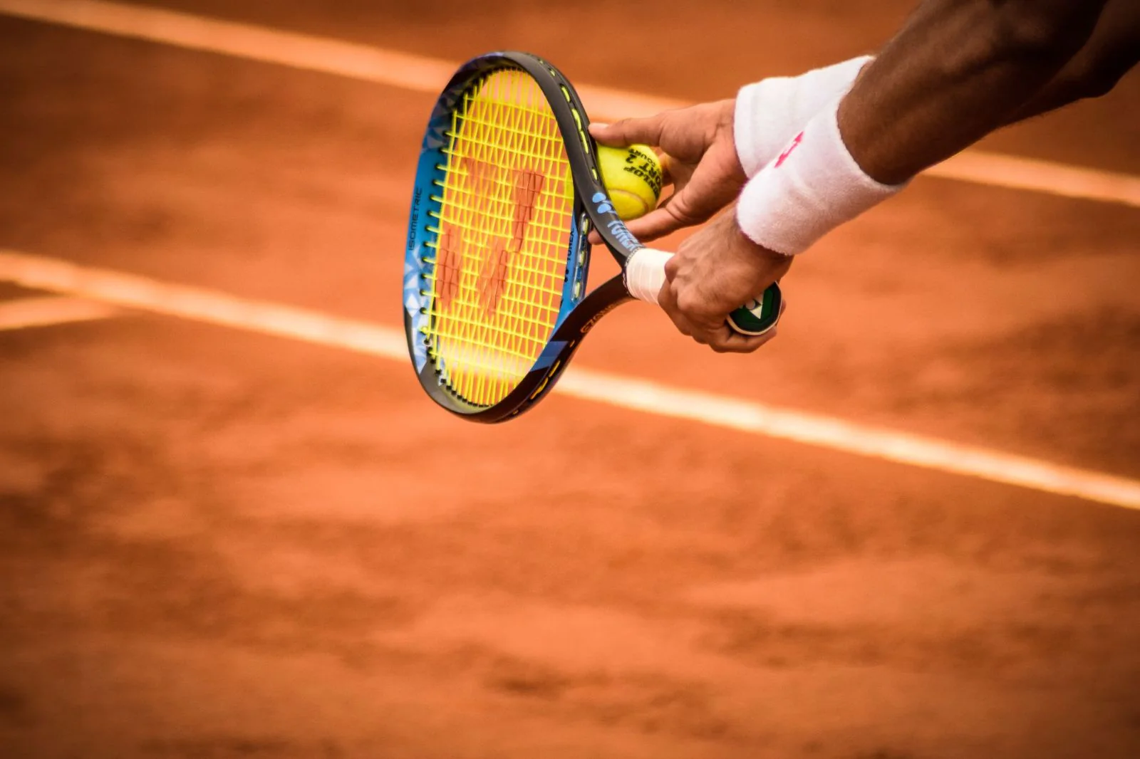 Saque de tenis sobre cancha de polvo de ladrillo